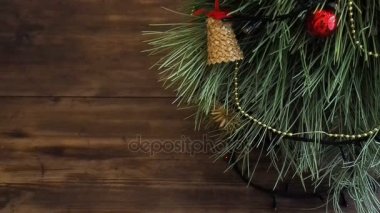 Adam hediye kutuları Noel ağacının altına koyar. Köknar ahşap masa standı ve parlayan garland ve Noel oyuncaklar ile dekore edilmiş.