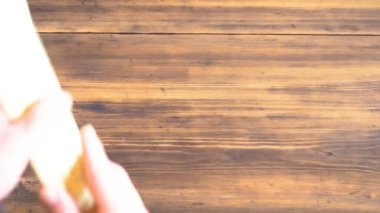 Adam ahşap masanın üzerine bambu yapılmış eski kurulları peçete koyar..