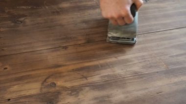 Erkek, marangoz değirmeni tutarak ve ahşap tahta yumuşatma ellerinizi kapatın.