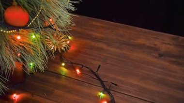 Adam hediye kutuları Noel ağacının altına koyar. Köknar ahşap masa standı ve parlayan garland ve Noel oyuncaklar ile dekore edilmiş.