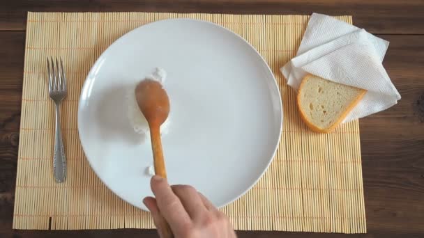 O homem coloca um arroz fresco e fumegante no prato branco uma colher de madeira . — Vídeo de Stock