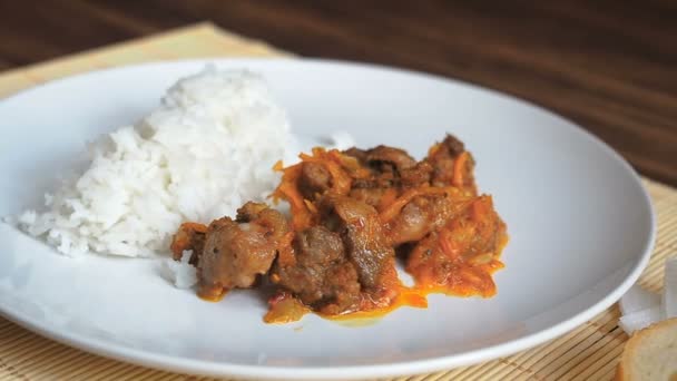 Prato de arroz fresco e fumegante. Cena em câmara lenta. Prato cerâmico branco de arroz e carne frita a verduras em guardanapo de bambu em uma mesa de madeira das velhas tábuas . — Vídeo de Stock