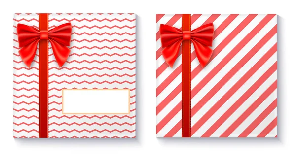 Geschenkboxen mit großer roter Schleife und Schleife auf weißem Hintergrund. — Stockvektor