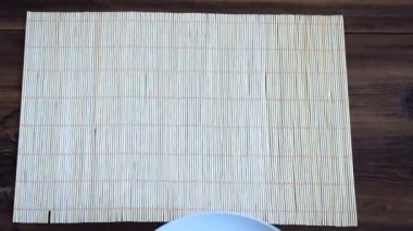 Adam ahşap masanın üzerine eski panolardan bambu beyaz fincan yapılan peçeteyle koyar