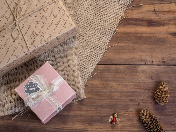 Caja de regalo vintage, conos de abeto, juguete de Navidad en madera y fondo de arpillera, vista superior de la foto. Copiar espacio para texto . — Foto de Stock