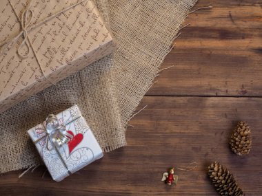 Vintage hediye kutusu, çam kozalakları, Noel oyuncak ahşap ve çuval bezi arka plan, fotoğraf üstten görünüm üzerinde. Metin için yer kopyalayın.