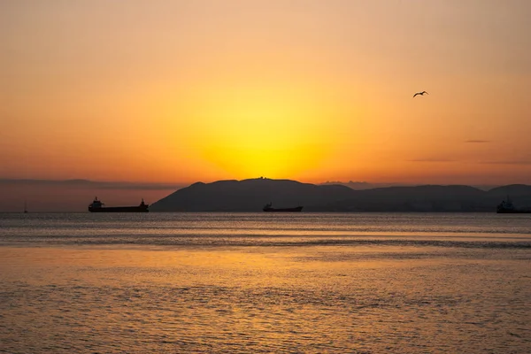 Puesta de sol natural de verano. Siluetas de barcos y franjas de tierra en el horizonte . — Foto de Stock