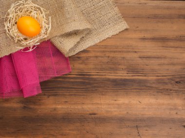 Kırsal çevre portakal tavuk yumurta ve saman çuval bezi ve eski ahşap plakalar arka plan üzerinde arka plan. Üstten Görünüm. Paskalya kartları için yaratıcı arka plan