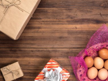 Paskalya yumurtaları sepet hediye kutuları, üstten görünüm ile eski kurulları ahşap tablo arka plan üzerinde.