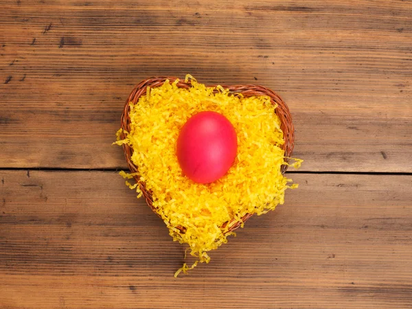 Huevo de gallina de color sobre fondo de paja de color amarillo brillante y mesa de madera vieja. La vista desde arriba . — Foto de Stock