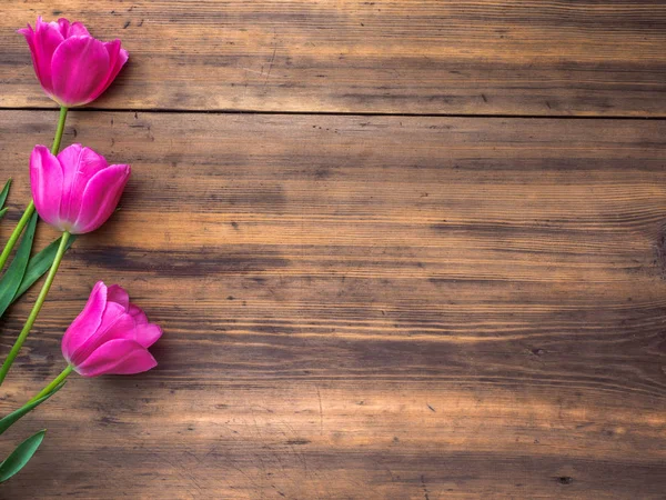 Tulipanes rosados, arreglo floral sobre fondo de madera de tablas viejas y un espacio para mensajes. Antecedentes para el Día de las Madres, 8 de marzo y otras tarjetas de felicitación para mujeres encantadoras. Enfoque suave, vista superior — Foto de Stock