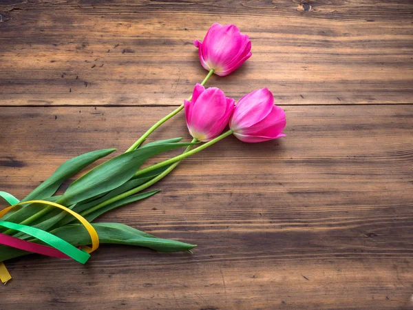 Różowe tulipany, klomb na podłoże drewniane od starych desek i wpisanie wiadomości. Tło na dzień matki, 8 marca i inne karty z pozdrowieniami dla pięknej kobiety. Nieostrość, widok z góry — Zdjęcie stockowe