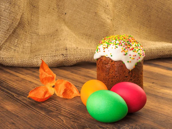 Pastel de Pascua y huevo de color Pascua con flor seca. Ruso y ucraniano, ortodoxo, kulich de Pascua tradicional eslava en el fondo rural de madera vieja y arpillera . — Foto de Stock