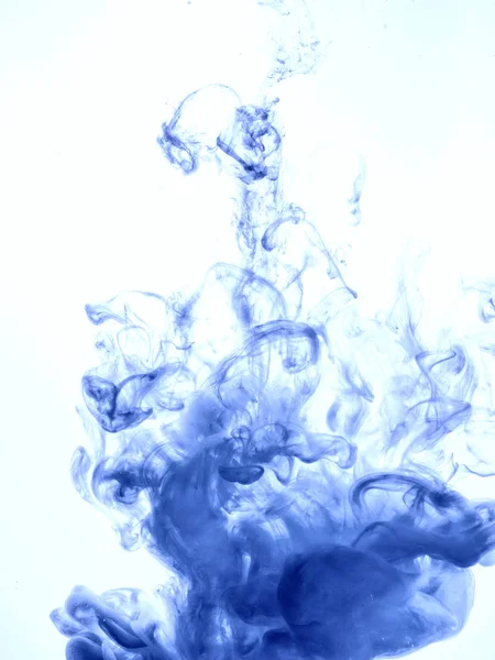 Remolino de tinta en agua aislada sobre fondo blanco. La pintura en el agua. Diseminación suave: gotas de tinta azul en el primer plano del agua. Fondo abstracto. Enfoque suave —  Fotos de Stock