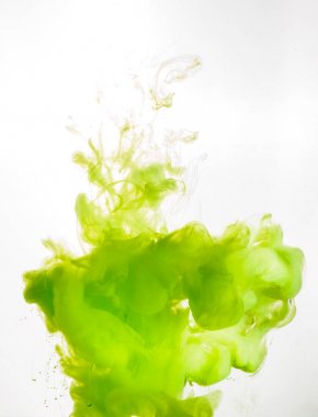 Ink swirl in water isolated on white background. The paint in the water. Soft dissemination a droplets of green ink in water close-up. Abstract background. Soft focus clipart