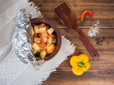 Tavuk etli patates bir seramik kase pişmiş. Natürmort ülke tarzı üzerinde arka plan eski ahşap ve kaba kumaş. Kaşık ve baharat, üstten görünüm mensup