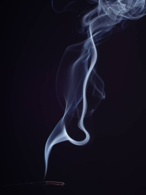 Girdap gibi beyaz duman buharı, siyah arka planda izole edilmiş, yakın görüş. Tütsü yakmanın soyut arka planı, fırça etkisi. Meditasyon ve rahatlama için doğu parfümü.