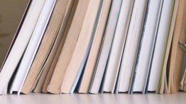 Dolly kitap rafı boyunca kayar, soldan sağa hareket eder. Yırtık sayfalı eski kitaplar yenilerinin yanında durur. Kitaplar kitaplıkta. Kapalı..