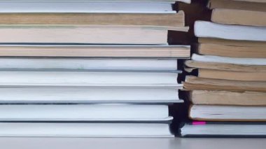 Dolly kitap yığınları boyunca kayıyor. Kitap rafı boyunca soldan sağa hareket ediyor. Kitaplar istiflenmiş. Kitaplar kitaplıkta. Kapalı..