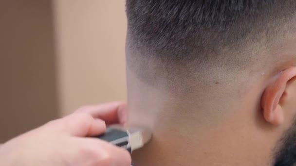 Samci zátylku, blízko. Stylista stříhá klientům vlasy nůžkami. Muž v kadeřnickém salónu. Selektivní měkké zaměření. Rozmazané pozadí. — Stock video