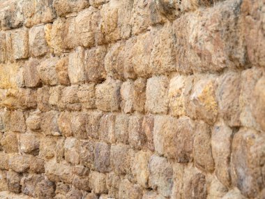 Eski bir kumlu duvar, yakın görüş. Taş duvar yapısı, soyut arkaplan. Seçici yumuşak odaklanma. Bulanık arkaplan.