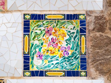 Barselona, İspanya - Ağustos 2019: Duvarda çok renkli soyut mozaik, yakın görüş. Soyut model. Barcelona 'daki Park Guell, Antonio Gaudi tarafından tasarlandı. Seçici yumuşak odaklanma. Bulanık arkaplan.
