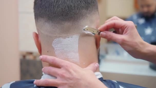 Nahbeschnittene Männchen nackt mit Rasiermousse, Nahaufnahme. Stylist rasieren Kunden Nacken mit offenem Rasiermesser. Mann im Friseursalon. selektiver weicher Fokus. verschwommener Hintergrund. — Stockvideo