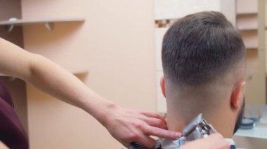 Usta siyah tarak ve kırpıcı ile saç kesme ustası, yakın çekim. Erkekler yakın doğrama boynu. Kuaför salonundaki adam. Seçici yumuşak odaklanma. Bulanık arkaplan.