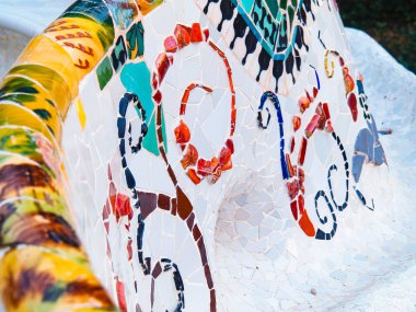 Barselona, İspanya - Ağustos 2019: Mozaikle kaplı banklar, yakın görüş. Soyut mozaik desen. Barcelona 'daki Park Guell, Antonio Gaudi tarafından tasarlandı. Seçici yumuşak odaklanma. Bulanık arkaplan.