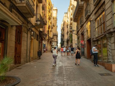 Barselona, İspanya - Ağustos 2019: binalar arasında uzun bir yol, uzun manzara. Kaldırımda yürüyen insanlar. Binanın yakınında beyaz bir minivan. Seçici yumuşak odaklanma. Bulanık arkaplan.