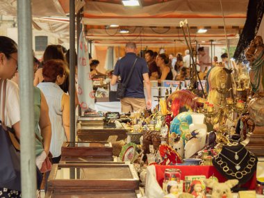 Barselona, İspanya - Ağustos 2019: hatıra sokak pazarında bir sürü turist, orta manzara. Hediyelik hediyelerle dolu raflar. Barselona 'da alışveriş. Seçici yumuşak odaklanma. Bulanık arkaplan.