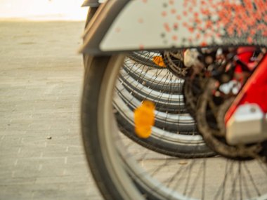 Bisikletlerin arka tekerleri, yakın görüş. Barcelona 'da bisiklet parkı, arka plan. Motosikletlerin arka tekerlerinin detayları. Seçici yumuşak odaklanma. Bulanık arkaplan.