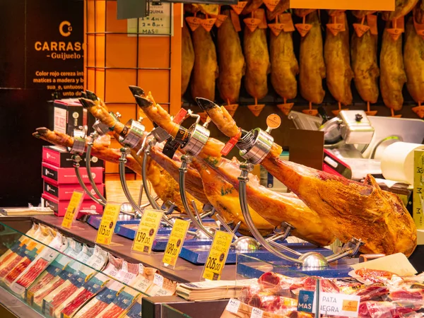 Barselona, İspanya - Ağustos 2019: farklı türde jamon kasaplığı rafları, orta manzara. Barselona 'da alışveriş. Jamon arka planı. Seçici yumuşak odaklanma. Bulanık arkaplan. — Stok fotoğraf