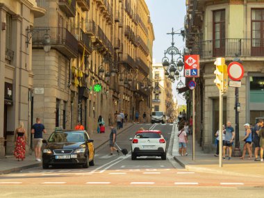 Barselona, İspanya - Ağustos 2019: binalar arasında yol alan arabalar, orta manzara. Sokakta yürüyen insanlar. Şehir merkezi trafiği. Seçici yumuşak odaklanma. Bulanık arkaplan.