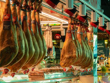 Barselona, İspanya - Ağustos 2019: Asma jamonlu kasap rafı, orta manzara. Barselona 'da alışveriş. Seçici yumuşak odaklanma. Bulanık arkaplan.