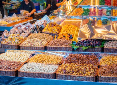 Fındık ve kuru meyvelerle dolu pazar rafları, orta manzara. Manav rafları arka planda. Fındık ve meyve paketleyen satıcılar. Seçici yumuşak odaklanma. Bulanık arkaplan.