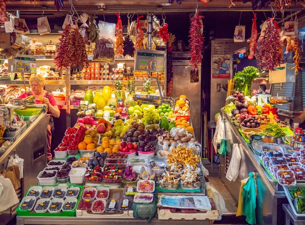 Manav ve yaşlı kadın tezgahın arkasında, orta manzaralı. Taze sebze ve meyve dolu pazar rafları. Sebze arka planı. Seçici yumuşak odaklanma. Bulanık arkaplan.