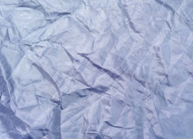Dark blue crumpled textile, close up view. Dark blue fabric, an abstract background. Crumpled sheet texture. Background for banners, or wallpapers.