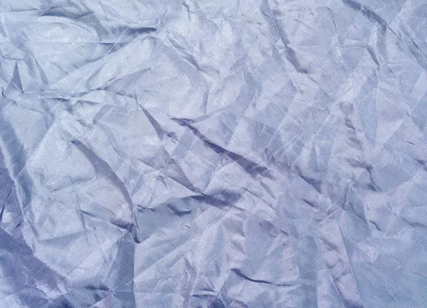 Dark blue crumpled textile, close up view. Dark blue fabric, an abstract background. Crumpled sheet texture. Background for banners, or wallpapers.