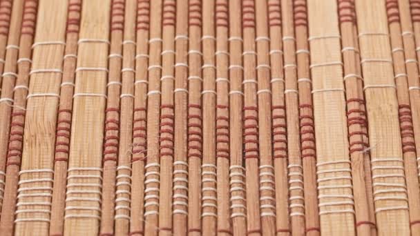 Paneles de bambú marrón, tiro cerrado. Dolly tiro de panel de bambú atado con una cuerda, fondo abstracto. Textura de paneles de bambú. Enfoque suave selectivo. Fondo borroso . — Vídeo de stock