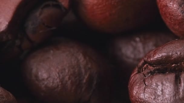 Langzaam glijdende beweging langs een hoop bruine koffiebonen, close-up. Stapel gebrande koffiebonen, dolly shot. Selectieve zachte focus. — Stockvideo