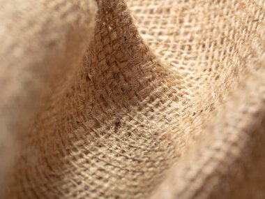 Buruşuk çuval bezi kumaşına yakından bak. Kahverengi çuval bezi dokusu. Buruşuk çuval bezi tekstili, soyut arka plan. Seçici yumuşak odaklanma. Bulanık arkaplan.