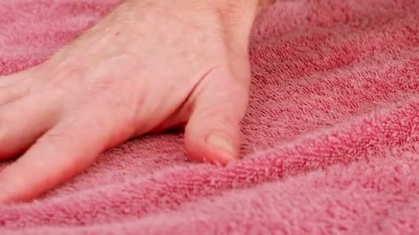 Mans hand strokes the Terry cloth. Close-up of the hand on the background of the fabric texture, macro shot. Fabric of towel, close up. Static camera. Close-up view — Αρχείο Βίντεο
