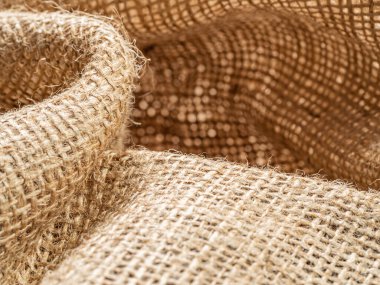 Kahverengi balina. Buruşuk çuval bezi, yakın görüş. Kahverengi çuval bezi dokusu. Buruşuk çuval bezi tekstili, soyut arka plan. Seçici yumuşak odaklanma. Bulanık arkaplan.