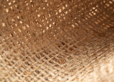 Buruşuk çuval bezi tekstili, yakın görüş. Kahverengi çuval bezi, soyut arka plan. Kahverengi balina dokusu. Seçici yumuşak odaklanma. Bulanık arkaplan.