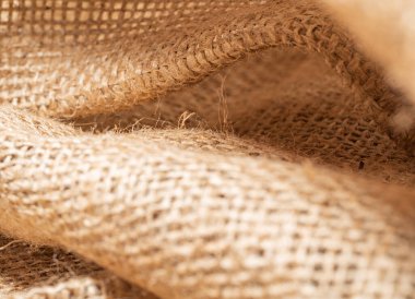 Buruşuk çuval bezi kumaşına yakından bak. Kahverengi balina, soyut arka plan. Kahverengi çuval bezi dokusu. Seçici yumuşak odaklanma. Bulanık arkaplan.