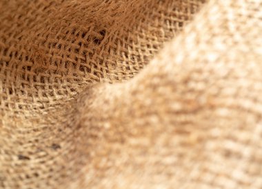 Buruşuk çuval bezi, yakın görüş. Kahverengi çuval bezi dokusu. Kahverengi çuval bezi tekstili, soyut arka plan. Seçici yumuşak odaklanma. Bulanık arkaplan.
