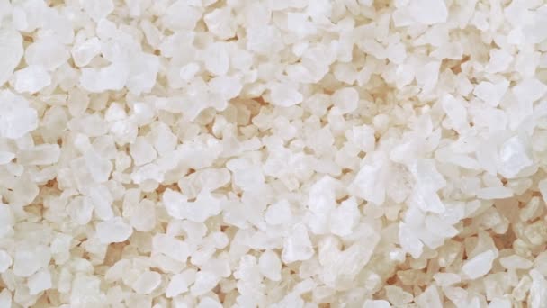 Heap of white sea salt, close shot. Dolly shot of pile of white salt. Close up view on salt crystals, abstract background. Selective soft focus. Blurred background. — Stock Video