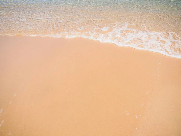 Goldener Sand am tropischen Strand in Meeresnähe. Meeresbrandung aus nächster Nähe. Sandstrand und sanfte Welle. — Stockfoto