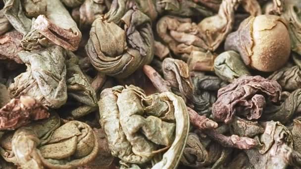 Heap of dried green tea leaves, close shot. Dolly shot of pile of dried tea leaves. Texture of tea leaves, abstract background. Selective soft focus. Blurred background. — Stock Video